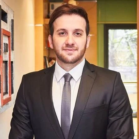 Dr. Rodolfo Afiune de terno, no consultório